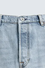 Pantalón de jean color celeste con efecto lavado, de corte recto y tiro medio, con diseño de cinco bolsillos y cierre frontal con botones.