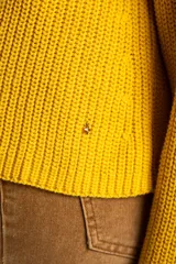 Sweater de punto en color amarillo, con diseño oversize, cuello redondo y manga larga. Presenta un pequeño bordado de un velero en la parte superior del pecho.