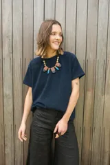 Remera oversize azul marino de tela con brillo y cuello redondo.