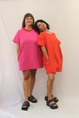 Remerón tipo vestido de corte holgado y manga corta, con cuello redondo en contraste y bolsillos laterales. Presenta un pequeño aplique decorativo en el pecho.