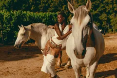 Falda corta de cuero en tono marrón con acabado desgastado, presenta bolsillos laterales grandes e irregulares y costuras decorativas visibles.
