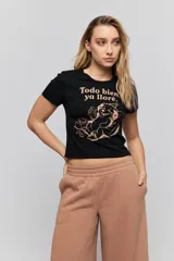 Remera negra de manga corta, con corte ajustado y estampa frontal en tono rosado que dice "Todo bien ya lloré" junto con un personaje ilustrado.