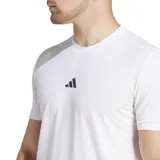 Remera de entrenamiento Adidas de manga corta, color blanco, con ajuste ceñido y logo de tres barras negras en el pecho. El cuello tiene una cinta interior con la inscripción "TRAINING".