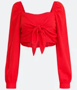 Blusa cropped roja de lino y viscosa, con escote cuadrado, mangas largas abullonadas y lazo frontal.