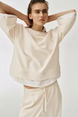 Sudadera de algodón color marrón con efecto doble capa, con cuello redondo y detalles en tejido blanco a contraste en las mangas y el bajo asimétrico.