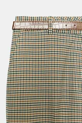 Pantalón de tiro alto color negro, de corte recto y pinzas frontales. Incluye un cinturón delgado de cuero marrón con hebilla metálica dorada.