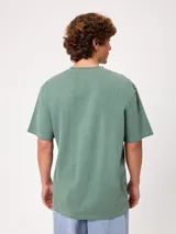 Remera de manga larga Rusty, color verde, con cuello redondo y ajuste holgado. Presenta un pequeño logo bordado en el pecho.