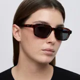 Lentes de sol con montura de diseño rectangular y esquinas redondeadas en estampado carey. Cuentan con lentes oscuras de nylon con protección UV400.