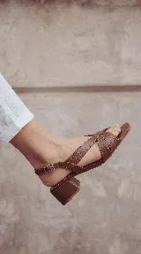 Sandalia de cuero bordó con tiras cruzadas en el empeine, taco cuadrado bajo y tira ajustable en el talón.