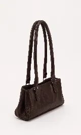 Cartera tipo baguette de cuero con textura, diseño rectangular y correas largas para hombro. Cuenta con forro interior, bolsillo amplio y broches laterales para ajustar su tamaño.