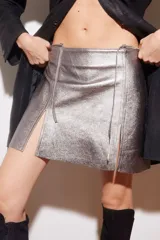 Minifalda plateada de cuero ovino con aberturas frontales.