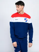 Buzo de felpa con cortes y cambios de color rojo, blanco y azul. Incluye el escudo del Club Nacional de Football y las siglas C.N.deF.