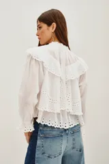 Camisa de algodón con diseño de encaje bordado, cuello mao, cierre frontal de botones y mangas largas con puños con volados.