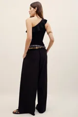 Pantalón ancho negro de tiro medio, con bolsillos laterales y pinzas frontales.
