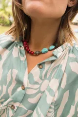 Vestido midi de corte camisero con estampado floral en tonos verde agua y crema. Presenta cuello a la base, cierre frontal con botones y mangas al codo con terminación elástica.