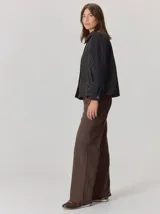 Campera de diseño híbrido con frente acolchado en color tostado, solapas y cuello en tejido de lana con patrón de cuadros tipo príncipe de gales, y mangas en paño de lana color azul marino. Cuenta con cierre frontal de botones.