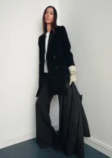 Abrigo midi de doble botonadura en color negro, confeccionado en mezcla de lana. Presenta cuello con solapas de muesca, manga larga y dos bolsillos laterales con solapa.