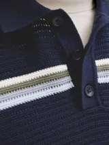 Sweater polo de punto a rayas horizontales en tonos azul marino, celeste, blanco y verde, de manga corta, con cuello camisero y cierre frontal de botones.