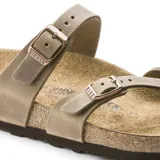 Sandalias Birkenstock Mayari en color marrón tabaco, con diseño de tiras cruzadas y separación para el dedo, equipadas con dos hebillas metálicas ajustables. Cuentan con plantilla anatómica de corcho y suela de EVA.