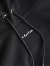 Buzo con capucha Calvin Klein de corte clásico, confeccionado en una mezcla de algodón y modal. Presenta bolsillo tipo canguro, cordones ajustables en el cuello y puños y dobladillo en punto canalé. Incluye un pequeño logotipo nano de la marca estampado en el centro del pecho.