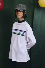 Remera de manga larga blanca con cuello alto en color azul. Presenta franjas horizontales de colores en el pecho y el logo de la marca estampado.