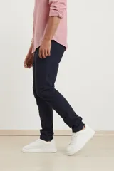 Pantalón azul oscuro de corte ajustado, con puños elásticos en los tobillos.