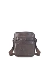 Morral de cuero vacuno con textura granulada, color marrón oscuro. Cuenta con múltiples compartimentos exteriores con cierre, correa ajustable al tono y herrajes metálicos.