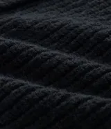 Cardigan de punto negro con textura acanalada, cierre frontal con botones, cuello redondo y mangas largas con puños ajustados.
