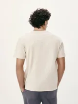 Remera de corte regular color beige con cuello redondo, mangas cortas y estampa frontal de pequeños nudos marineros en tono azul.