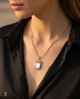 Collar de acero con baño de oro, con cadena tipo serpiente y dije rectangular con cristal central engastado.