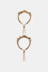 Pack de dos pulseras doradas con doble cordón metálico tipo malla, apliques decorativos de joyas a contraste y cierre corredizo con cuenta esférica.