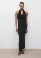 Vestido largo negro de corte entallado con cuello drapeado y espalda descubierta. Presenta un diseño sin mangas y una abertura trasera en el bajo.