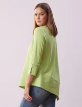 Blusa verde manzana en tejido acanalado, marca Ruby Rd. Largo de mangas ¾ con abertura y botones. Terminación de ruedo asimétrico.