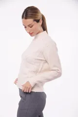 Suéter tejido color blanco con cuello alto y diseño de trenzas.