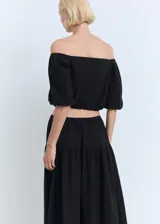 Blusa negra de diseño crop con escote palabra de honor, mangas cortas abullonadas y cintura elástica.