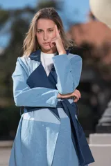 Tapado de jean con diseño color block en dos tonos de azul, con cuello solapa y lazo para atar en la cintura.