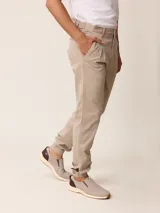 Pantalón bombacha de sarga azul marino, con pinzas en la cintura, bolsillos laterales y puños elásticos en los tobillos.