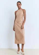 Vestido midi de lentejuelas color beige, con cuello halter, espalda descubierta y tirantes finos que se anudan al cuello.