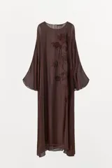 Vestido midi de viscosa color marrón, con cuello redondo, mangas largas amplias y diseño holgado. Presenta bordados en relieve con aplicación de abalorios a tono en el frente.