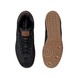 Championes adidas Samba OG de diseño clásico, con cuerpo en color negro, detalles en cuero marrón en el talón y lengüeta, y suela de goma color caramelo.