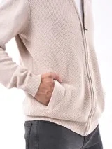 Campera tejida de punto con cierre frontal, cuello redondo y puños acanalados. Presenta una textura sutil en el tejido y un diseño versátil.