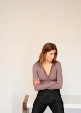 Body de manga larga color malva, con cuello tipo polo y escote en V pronunciado.