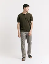 Remera color café de tejido de punto, con cuello polo y mangas cortas.