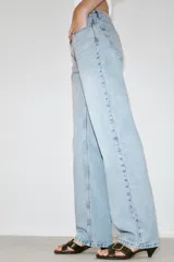 Jeans de tiro bajo con diseño de cinco bolsillos y pernera recta. Cierre frontal con cremallera y botón metálico.