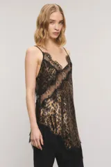 Top de satén con estampado animal print tipo leopardo y detalles de encaje negro en el escote y el ruedo asimétrico. Cuenta con breteles finos regulables y escote en V.