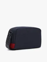 Cartera tipo camera bag Tommy Hilfiger de color azul marino, con compartimento principal con cierre, correa ajustable y desmontable, y parche con el logo de escudo de la marca bordado en el frente.