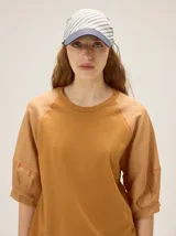Gorro estilo pañuelo con visera, confeccionado en lino, con diseño a rayas y detalles en color azul marino.