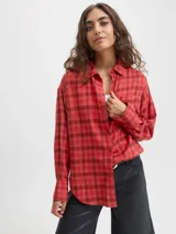 Camisa de franela twill color rojo con patrón de cuadros en tonos oscuros, corte relajado, mangas largas, cuello camisero, cierre frontal con botones y un bolsillo aplicado en el pecho.