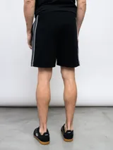 Bermuda deportiva celeste de piqué con cordón ajustable en la cintura, bolsillos laterales y logo Umbro estampado en blanco en la pierna izquierda.