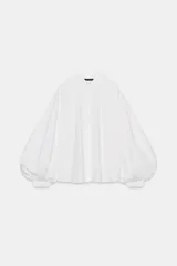 Camisa de cuello solapa y manga larga abullonada con puños ajustados. Presenta un cierre frontal con botones y un corte holgado.